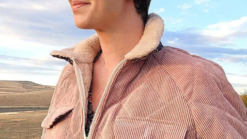 Close-up of a dusty rose corduroy jacket with a cream sherpa collar and zip front.