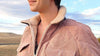 Close-up of a dusty rose corduroy jacket with a cream sherpa collar and zip front.