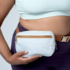 Handmade light blue denim belt bag with brown adjustable strap, gold zipper and buckle worn around the waist.