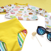 Handmade floral rash guard and yellow swimsuit bottoms with sunglasses