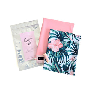Set of swim fabrics in  a tropical-themed pink palm with pink coordinating fabrics and sewing supplies 