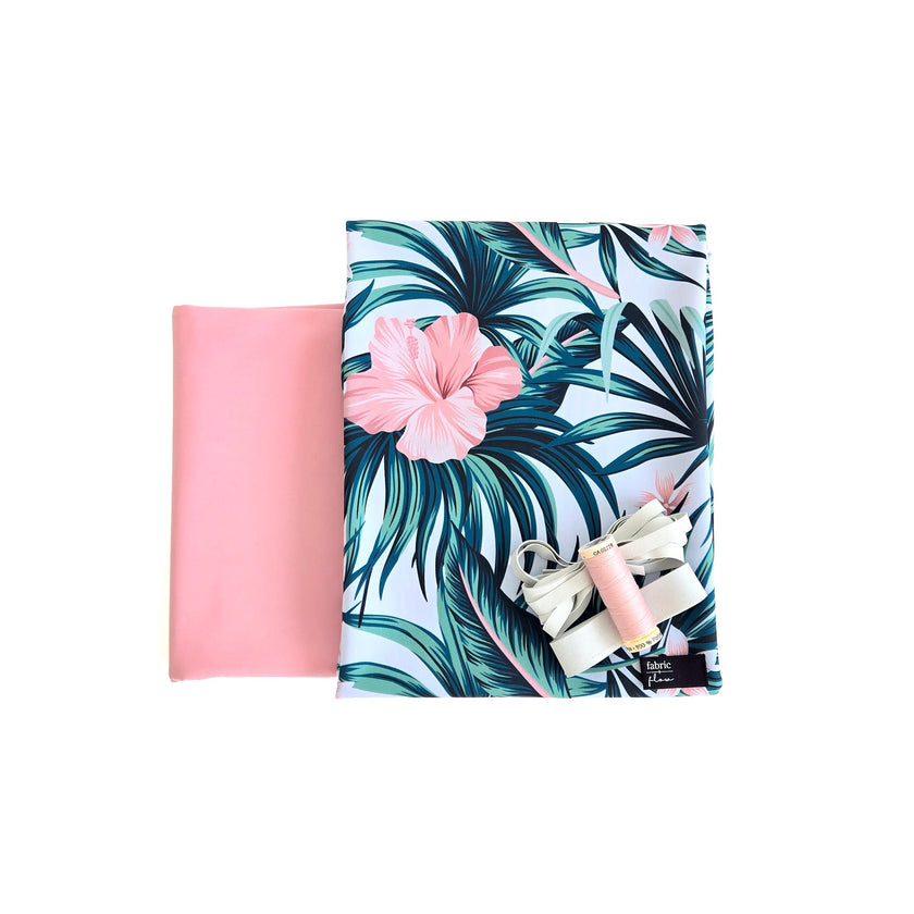 Tropical-themed product with pink flower and green leaves on a white background