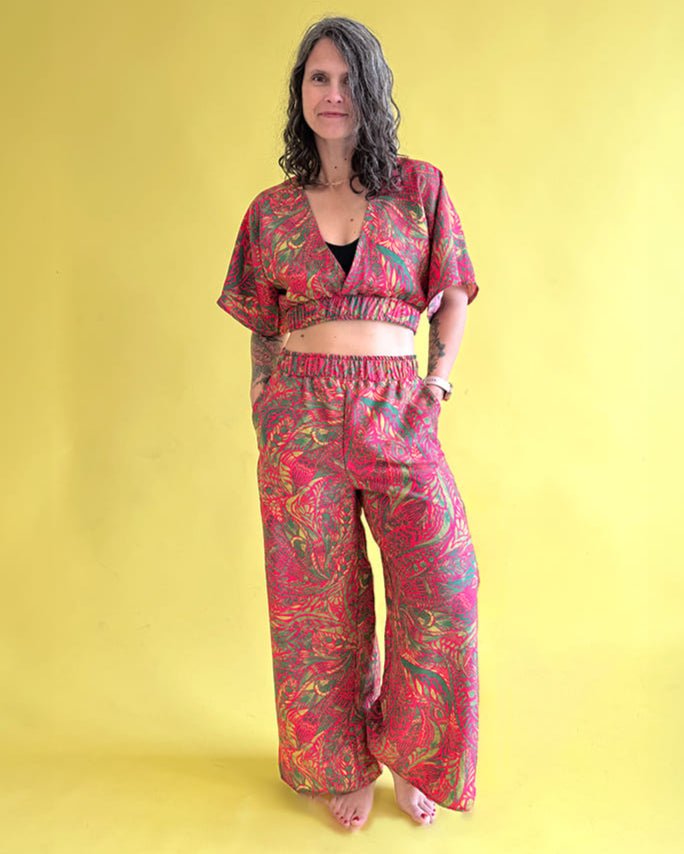 Woman wearing a red and pink patterned outfit on a yellow background
